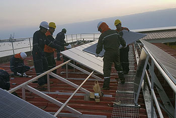 hombres instalando paneles solares sobre techo